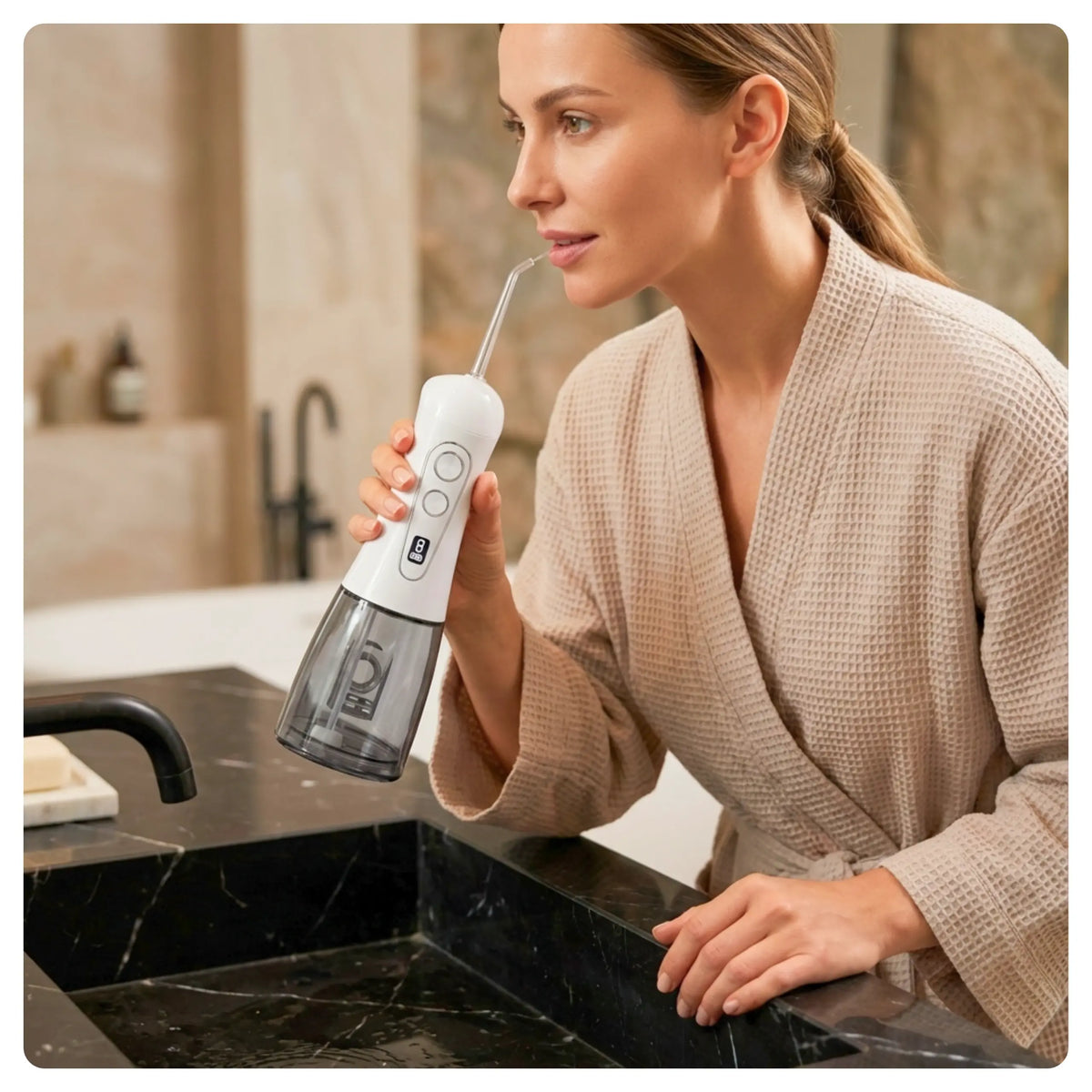 Woman using a white Avelora Apex water flosser while leaning over a marble sink.